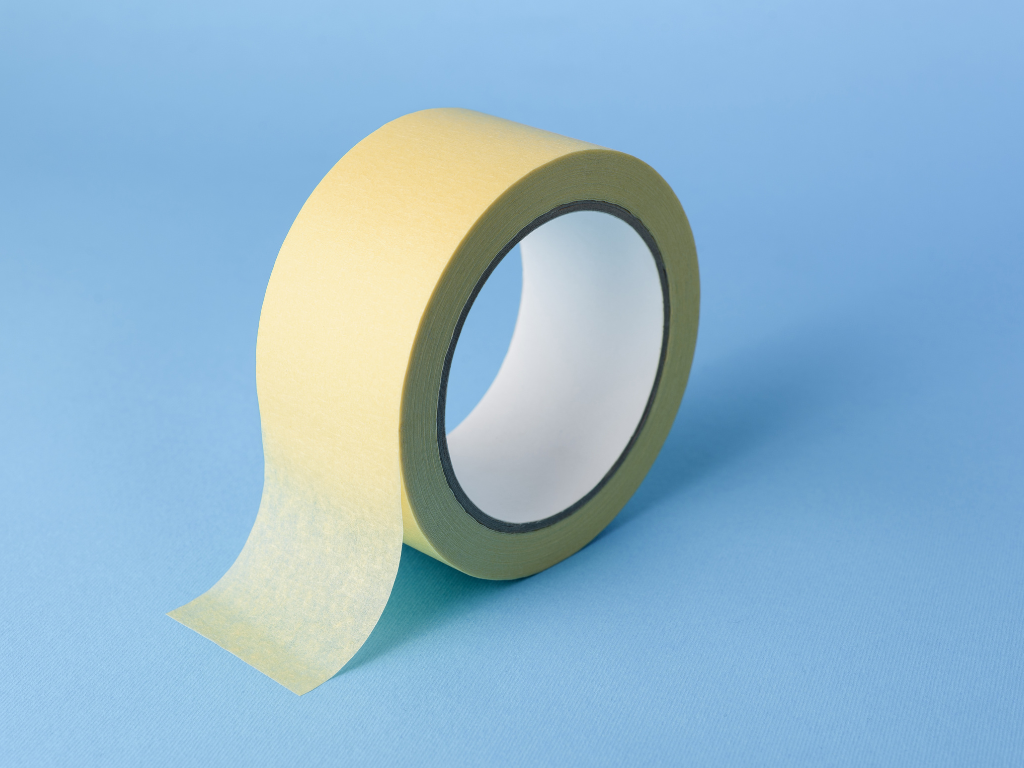 A roll of yellow tape on a blue surface