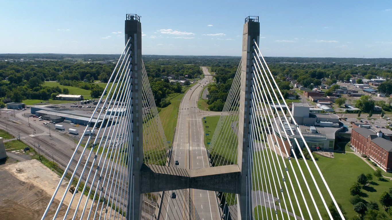 An aerial view of a bridge over a highway in a city.