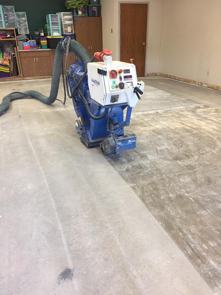 A machine is sitting on a concrete floor in a room.