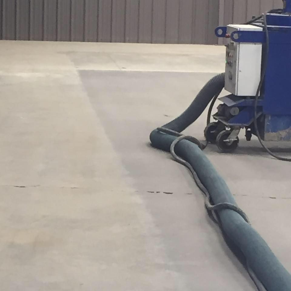 A hose is attached to a machine on a concrete floor