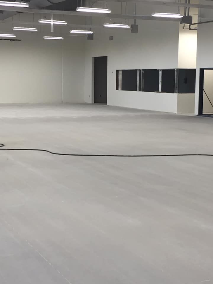 A large empty room with a vacuum cleaner on the floor.