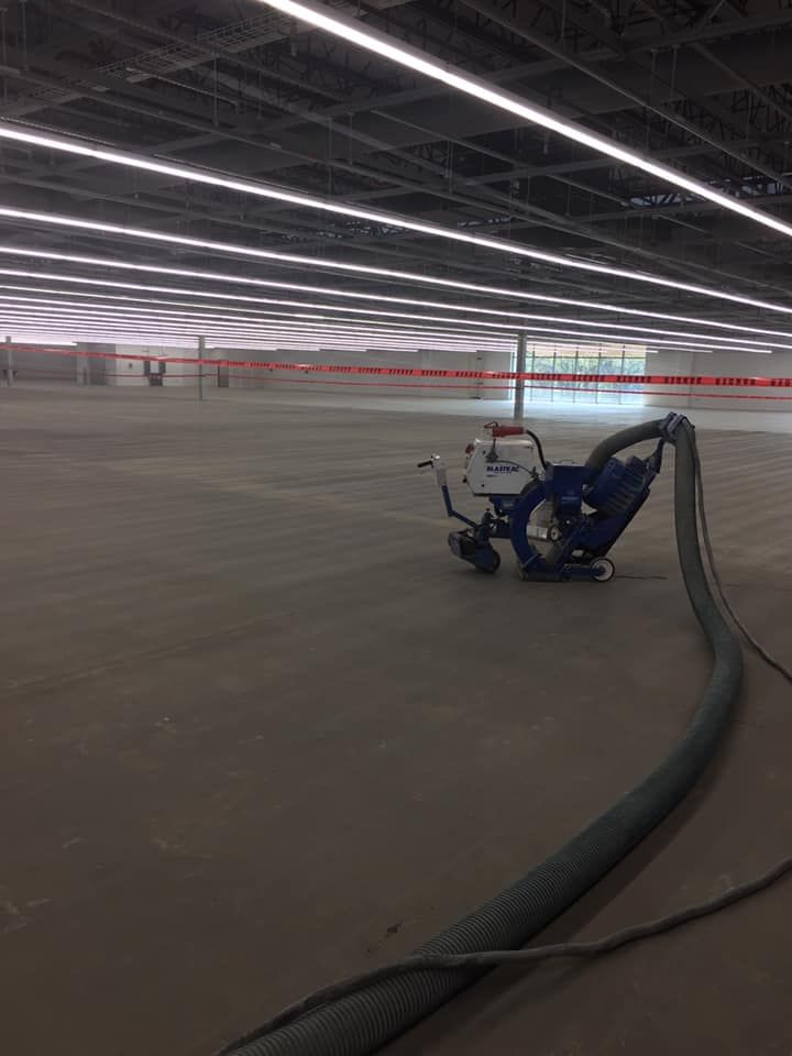 A machine is sitting in the middle of a large empty room.