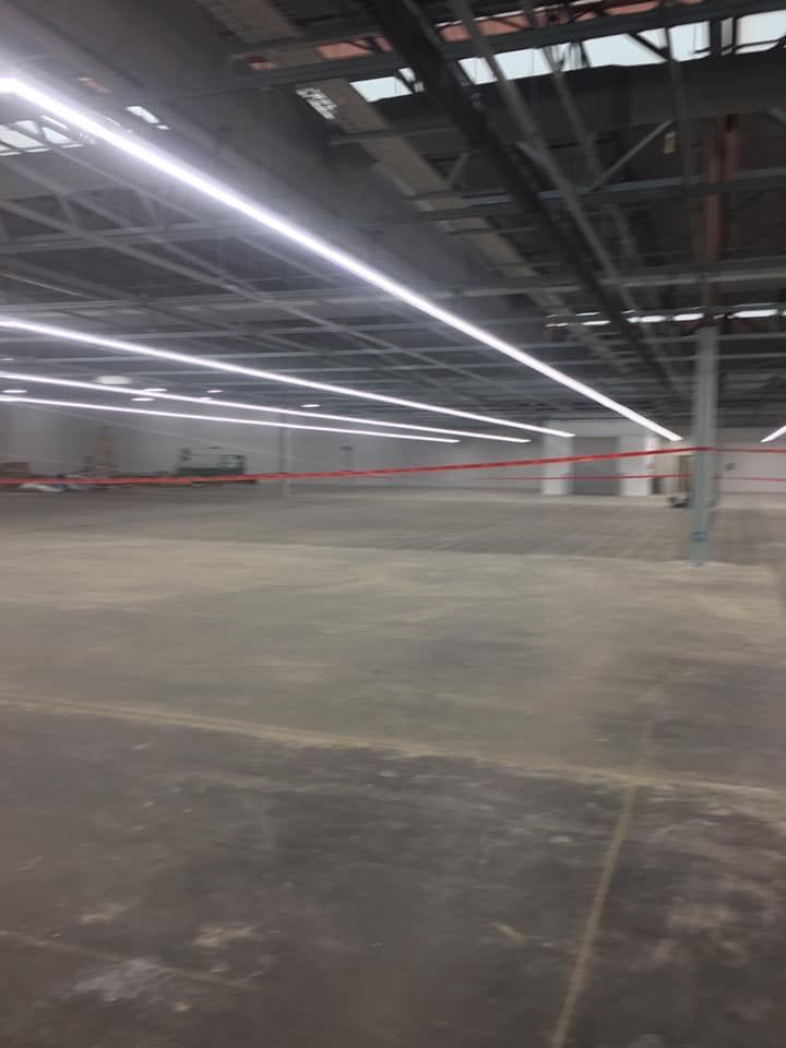 An empty warehouse with a lot of lights on the ceiling