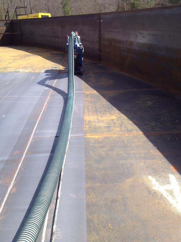 A hose is attached to a metal pole in a parking lot.