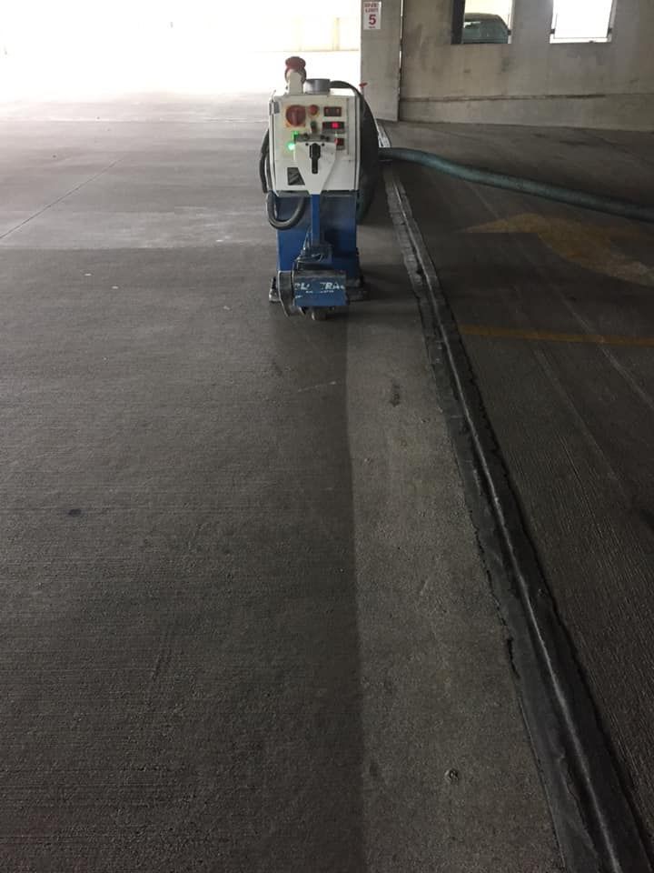 A machine is cleaning the floor of a parking garage.