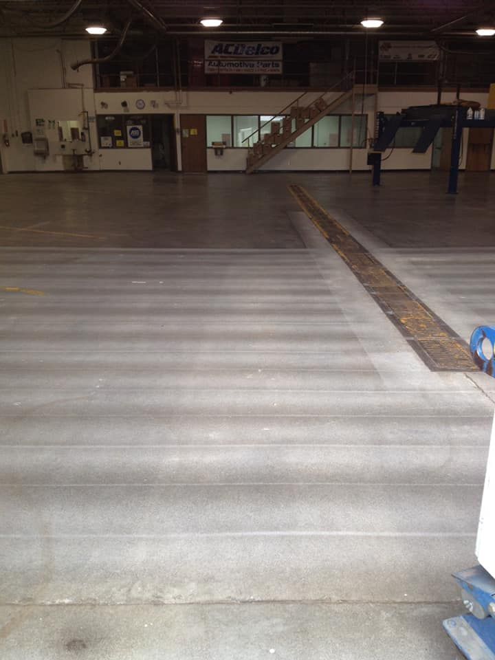 An empty warehouse with a sign that says acdelco on the wall.