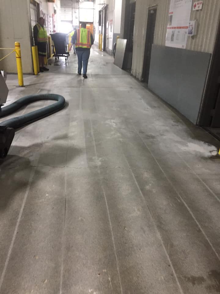 A man in a safety vest is walking down a hallway in a building.