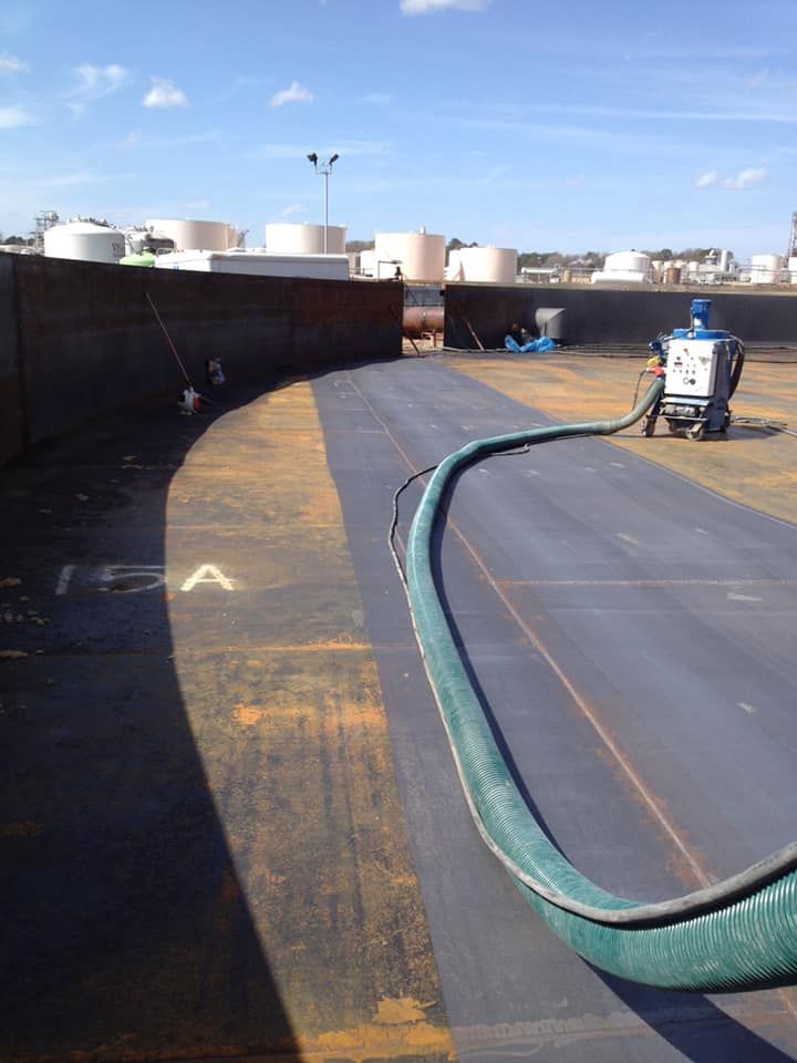 A hose is being used to clean a large tank.
