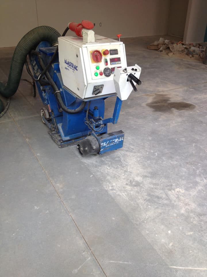 A machine is sitting on a concrete floor in a room.