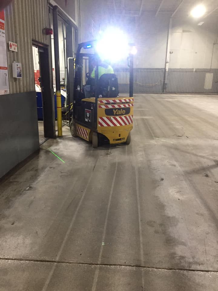 A man is driving a forklift in a warehouse.