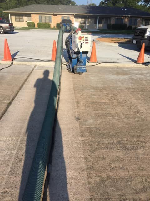 A machine is cutting concrete in a parking lot