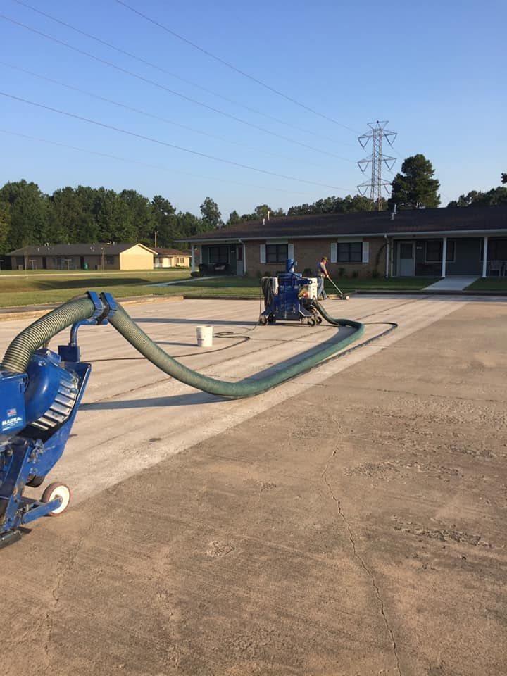 A blue vacuum cleaner is sitting on the side of a road in front of a house.