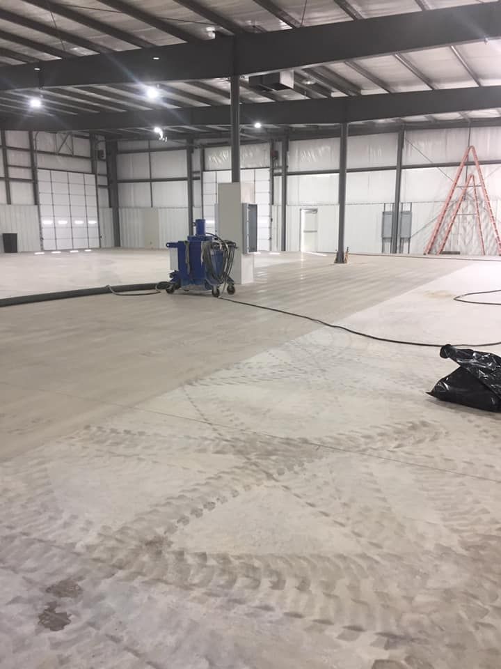 A large empty warehouse with a ladder in the background.