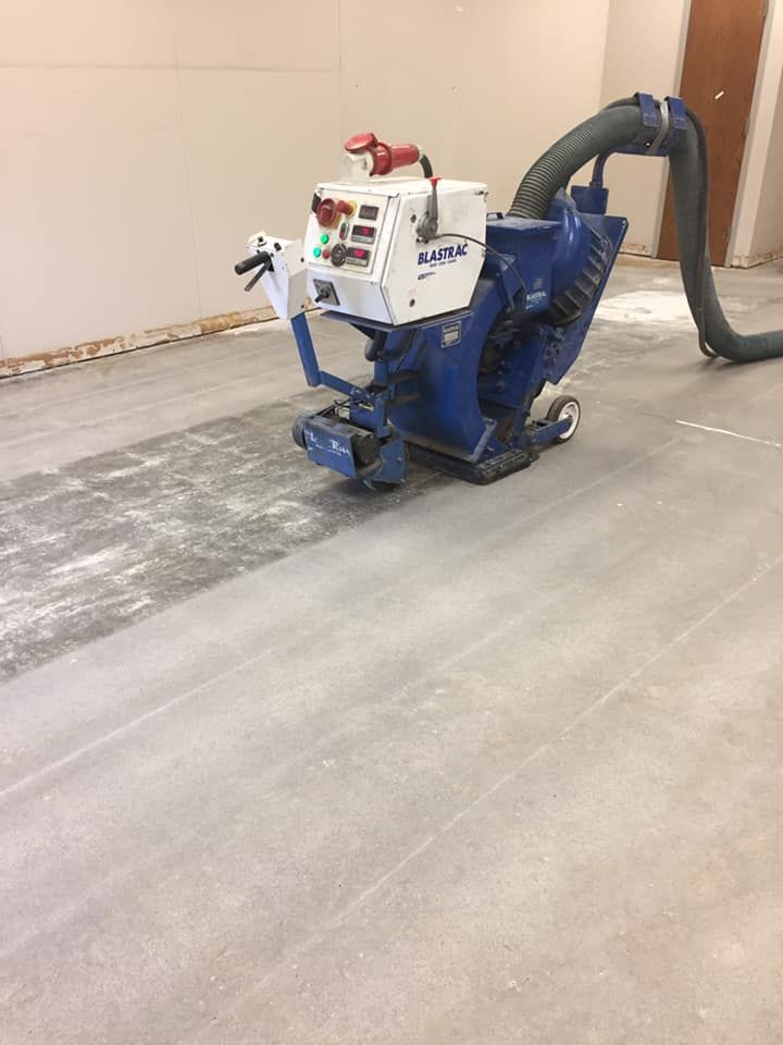 A machine is sitting on a concrete floor in a room.