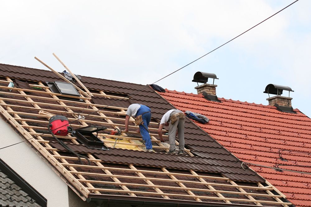 Two Men Are Working on the Roof of a House — Wagga Roof Repairs In Gundagai, NSW