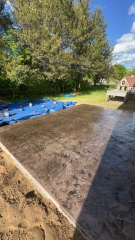 Brick pathway with herringbone pattern, surrounded by green grass. Beige benches are in the background.