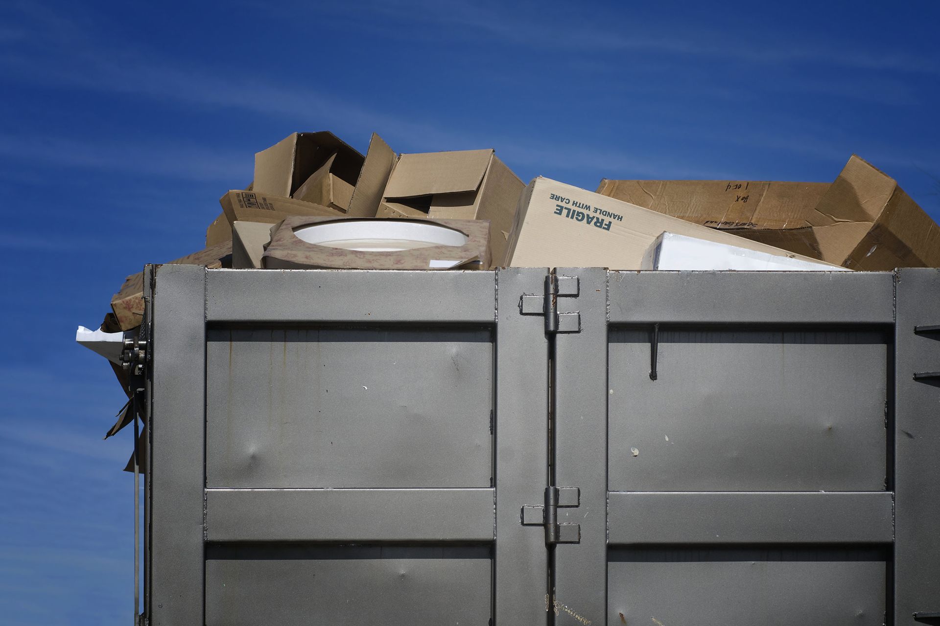 Dumpster Filled With Cardboard Boxes