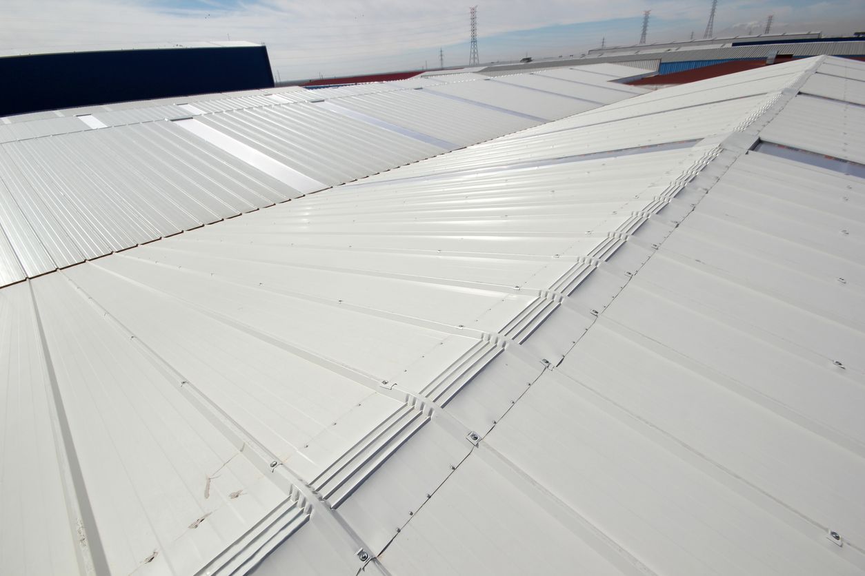White metal industrial building roof with angled ridges.