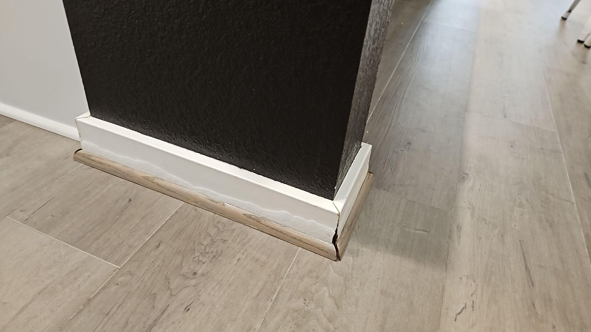 Baseboard showing signs of water damage during initial assessment in Hutto TX home