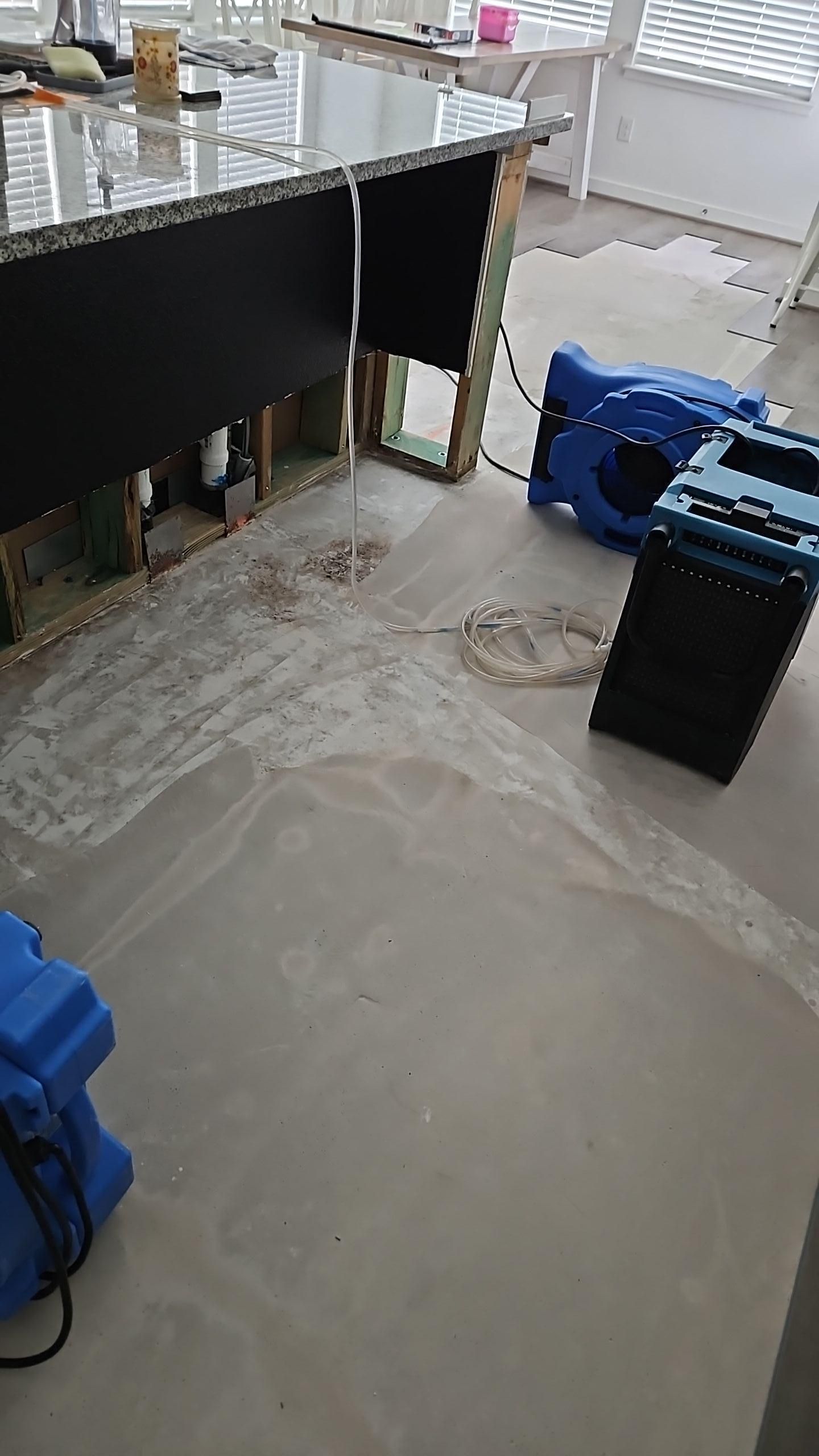Air movers and dehumidifiers working to dry the kitchen subfloor