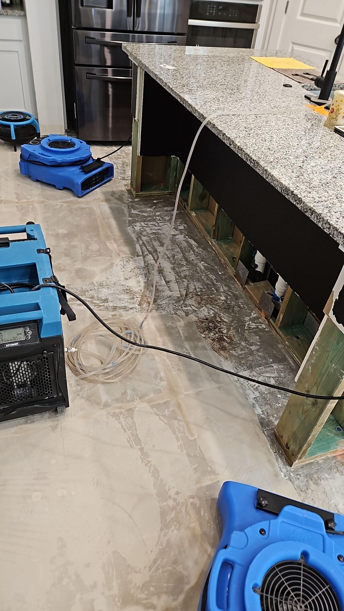 Kitchen flooring removed exposing subfloor with professional drying in progress