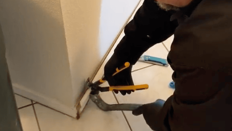 Texas Certified Restoration Expert removing water damaged baseboards