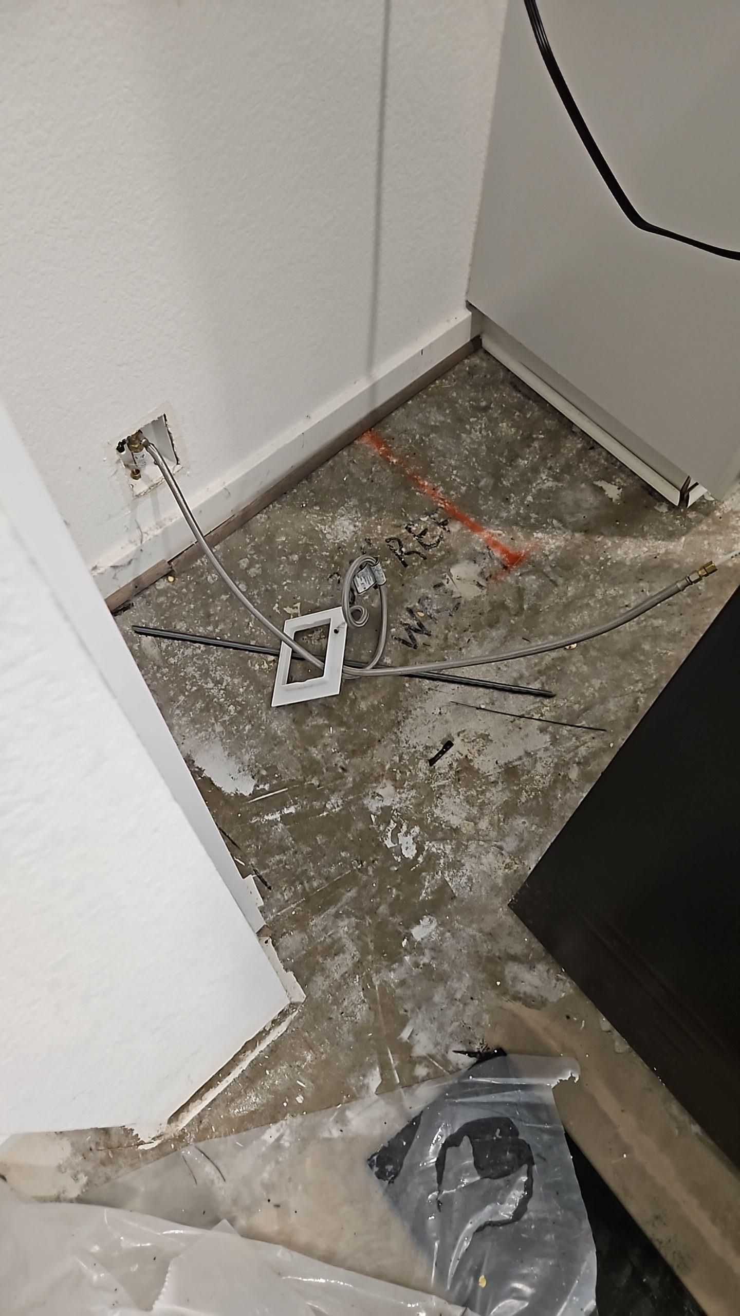 Damaged laminate flooring removed to expose wet subfloor during restoration