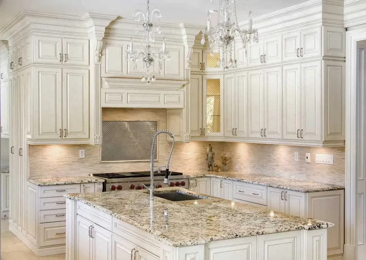 a kitchen with white cabinets and granite counter tops.