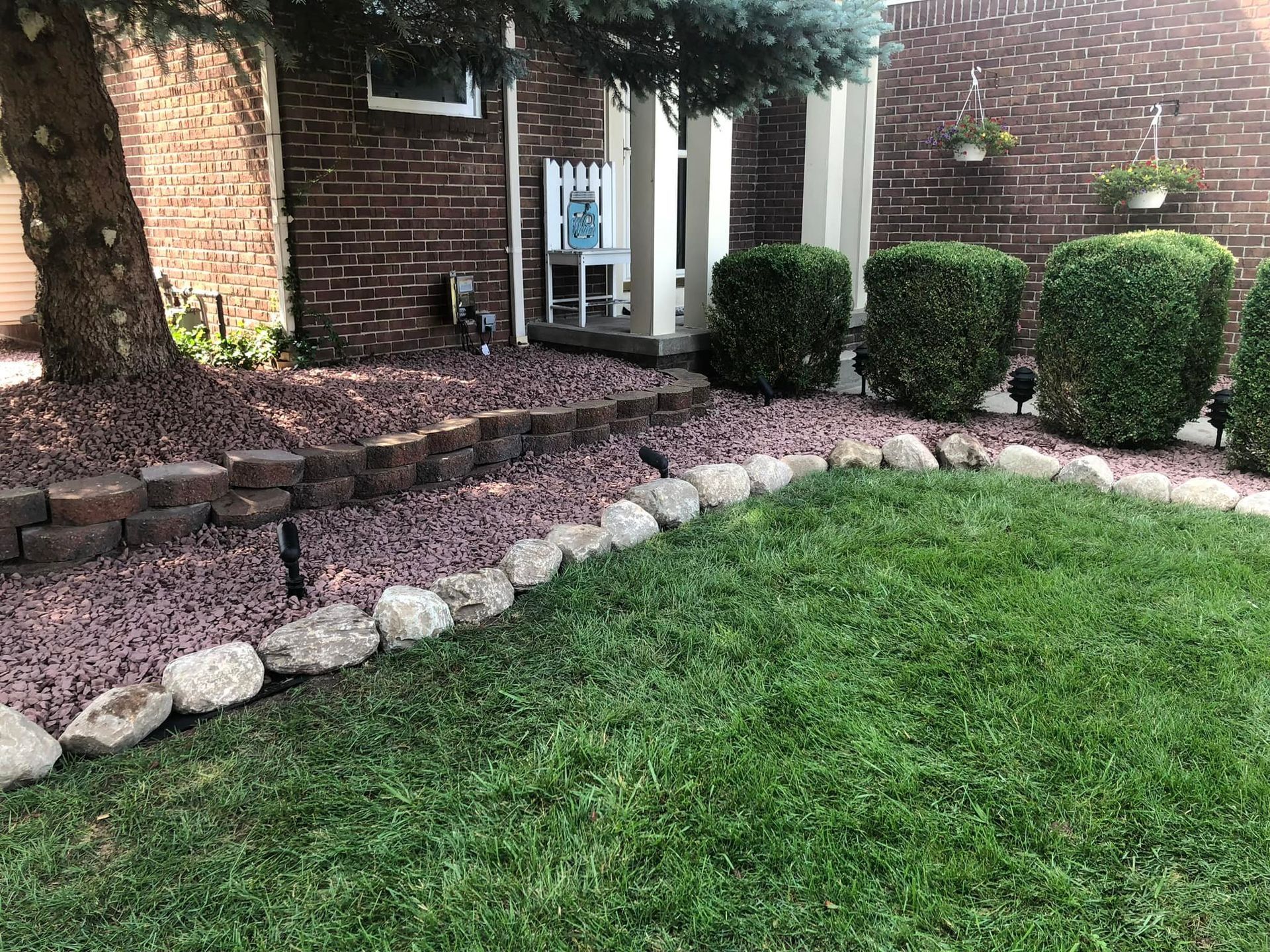 A brick house with a lush green lawn in front of it.