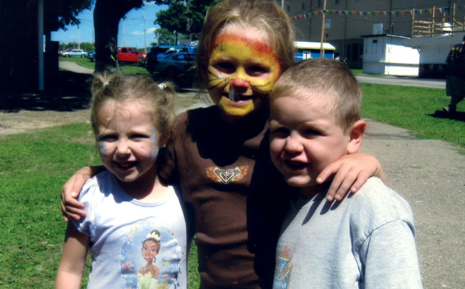 A boy and two girls are posing for a picture