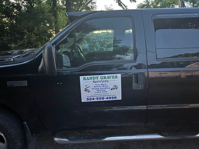 A black van with a sign on the door that says mandy graver