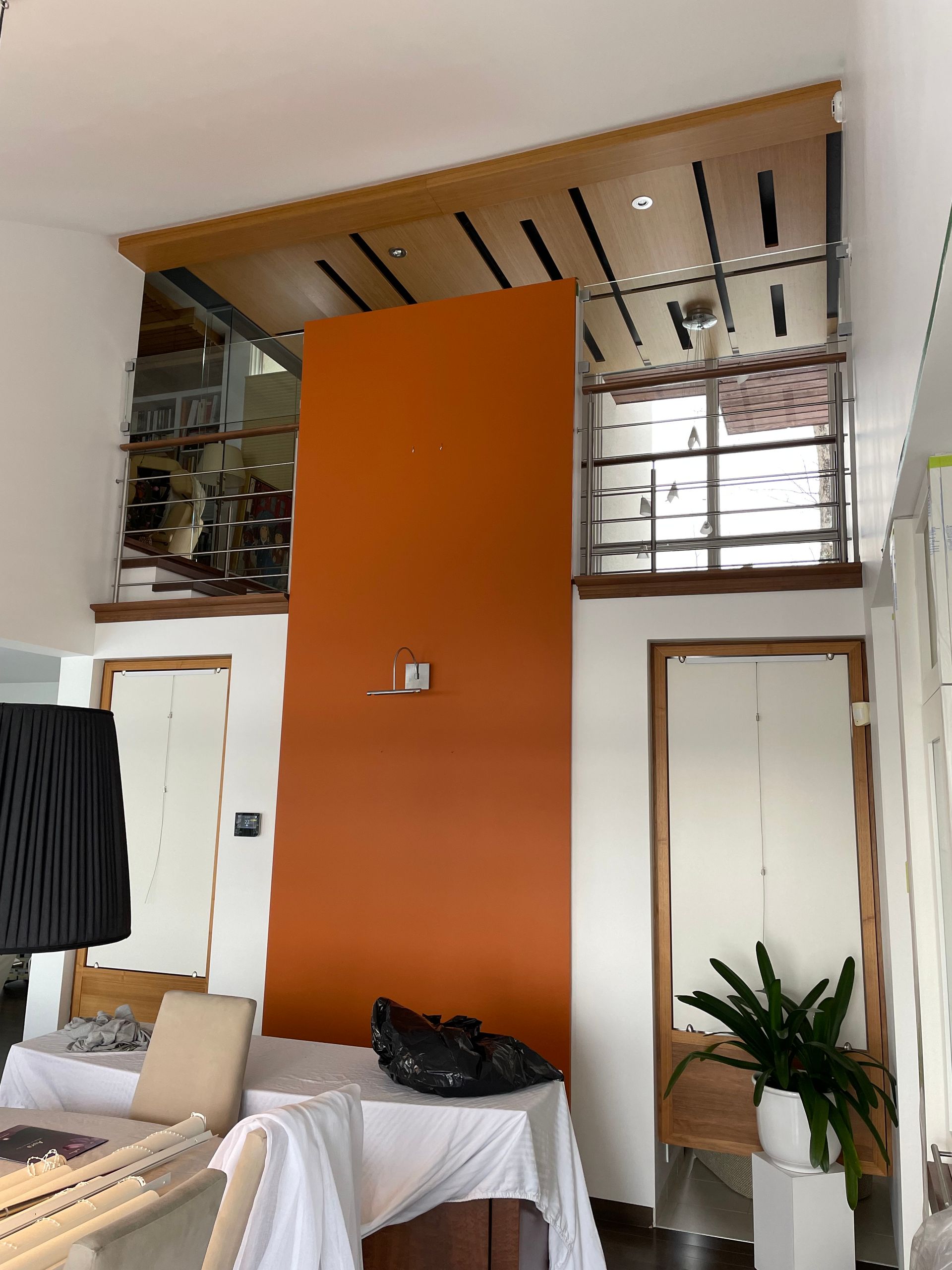 Un salon avec un grand mur orange et un escalier
