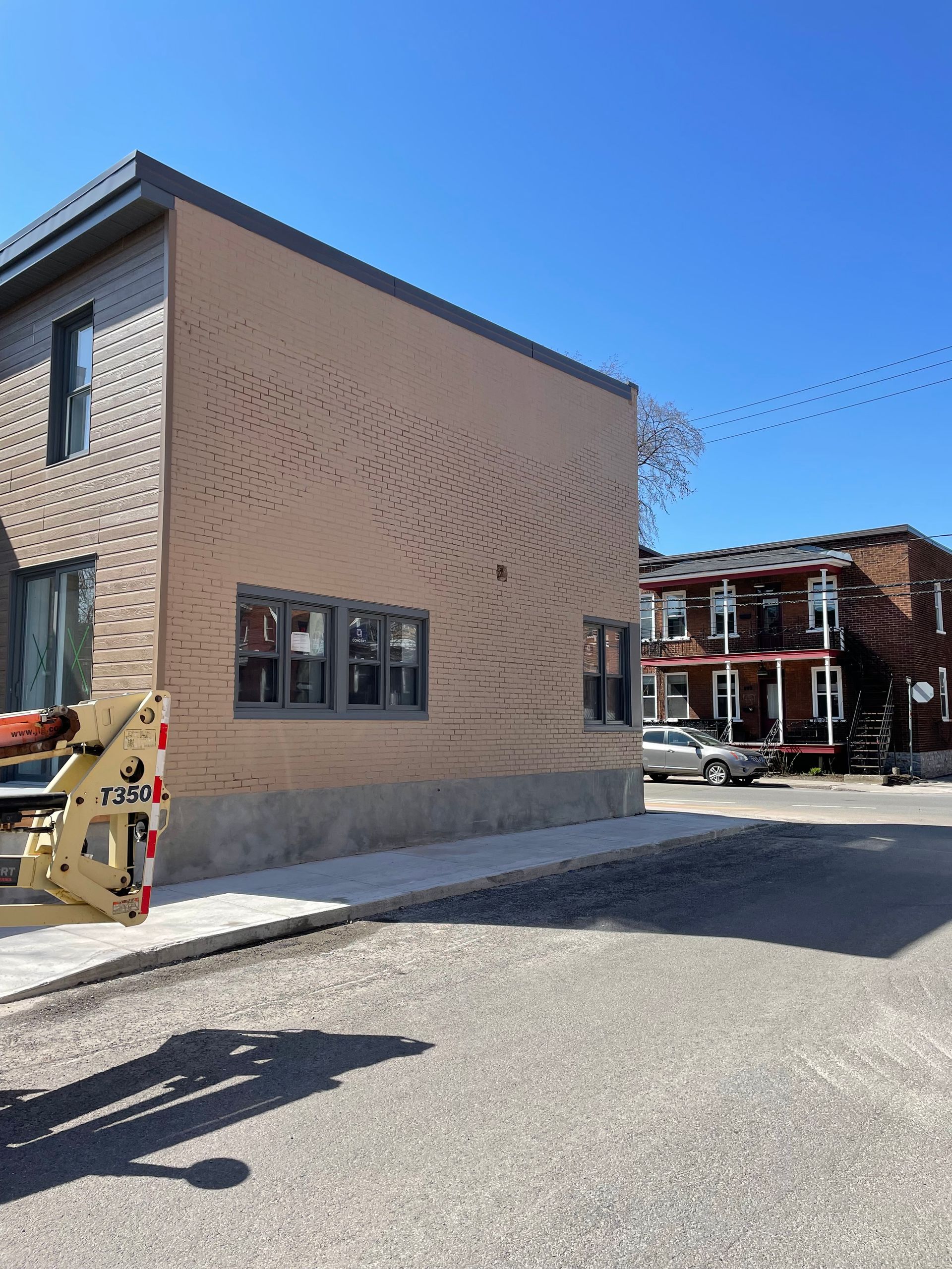 Un bâtiment avec beaucoup de fenêtres est en construction par une journée ensoleillée.