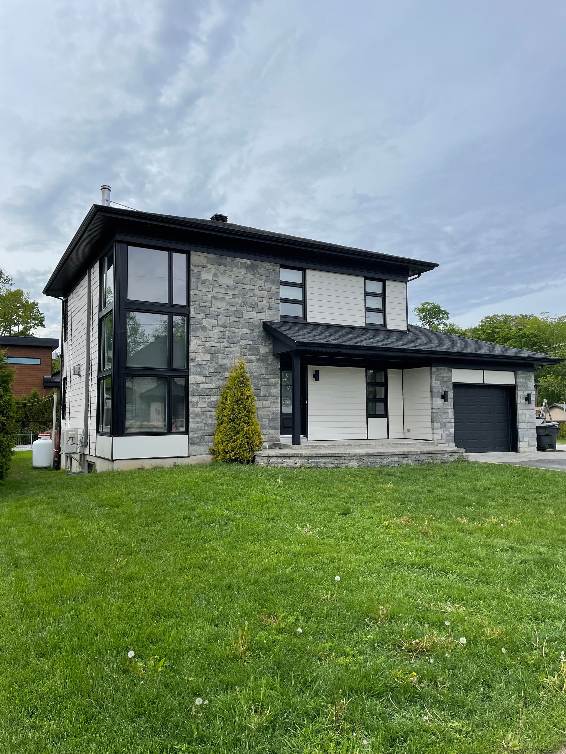 Une grande maison avec une grande pelouse devant.