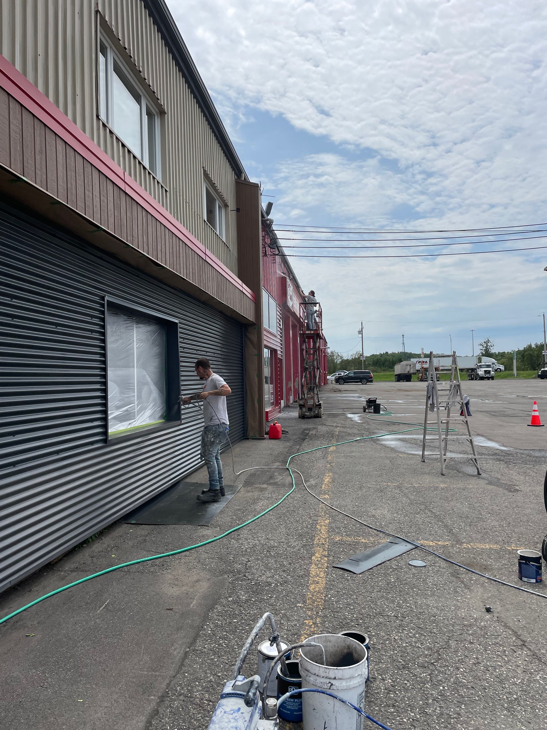Un homme peint le côté d'un immeuble.