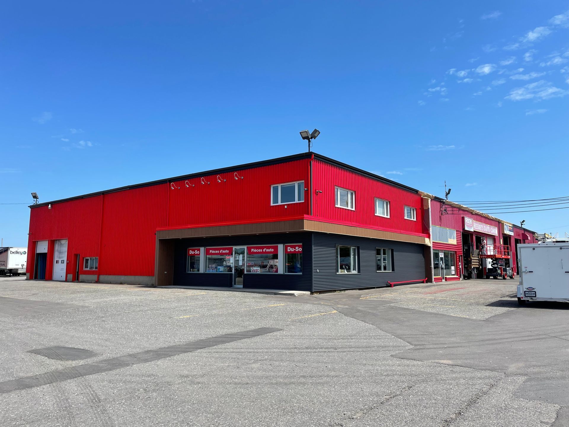 Un grand bâtiment rouge avec une caravane garée devant.