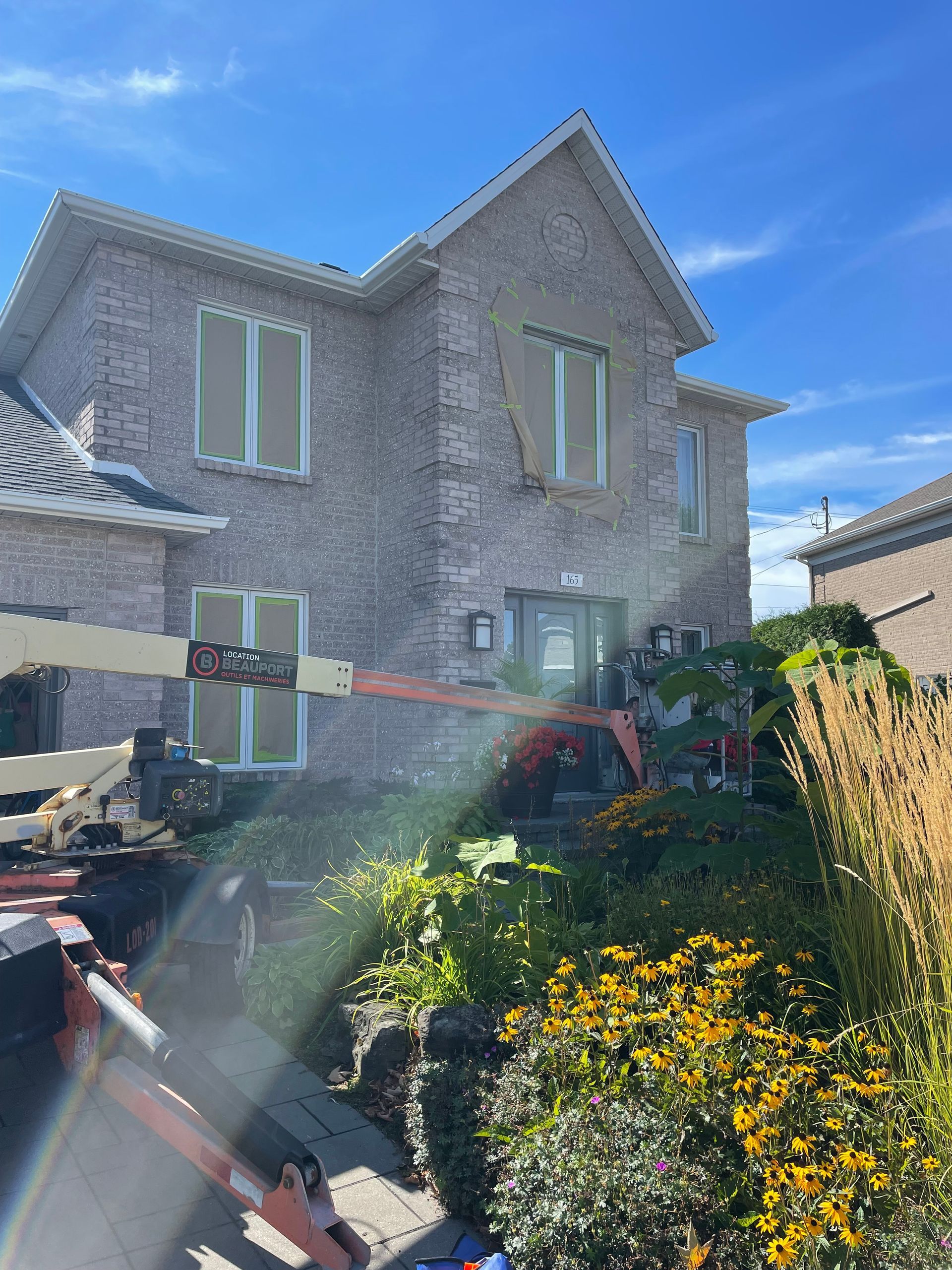 Une grande maison en brique est nettoyée avec une machine.