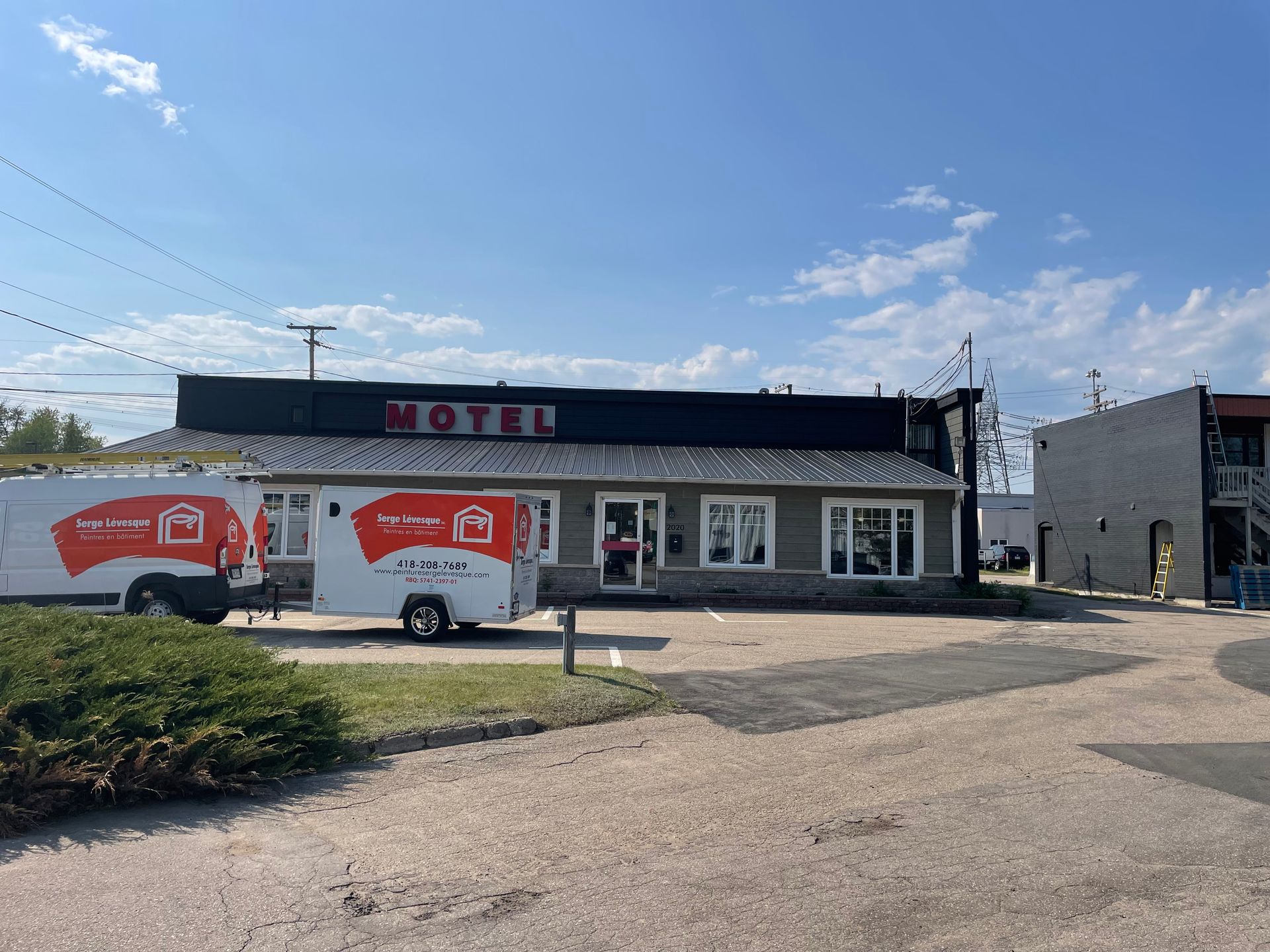 Un camion blanc est garé devant un motel.