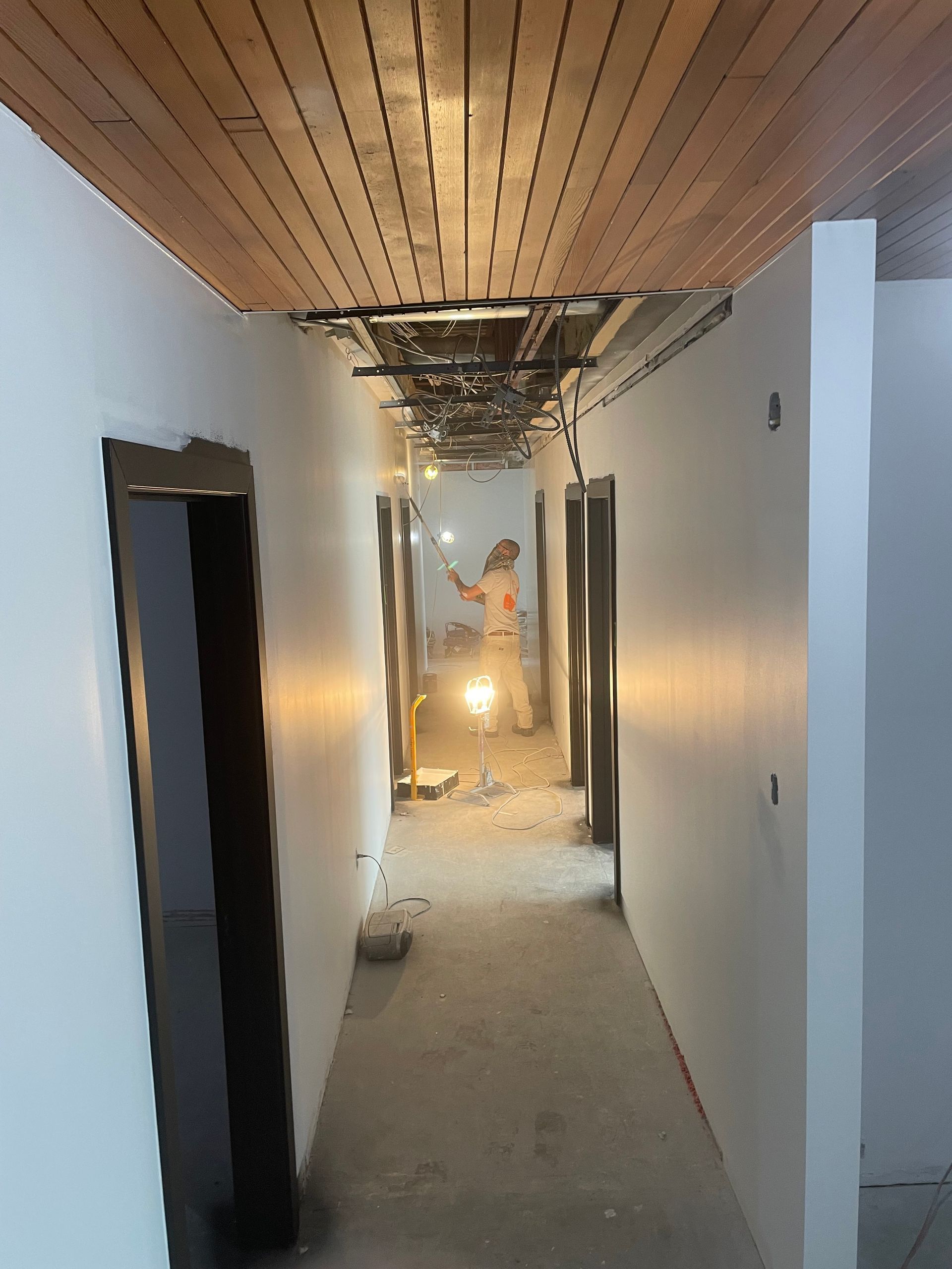 Un long couloir avec un plafond en bois et des murs blancs
