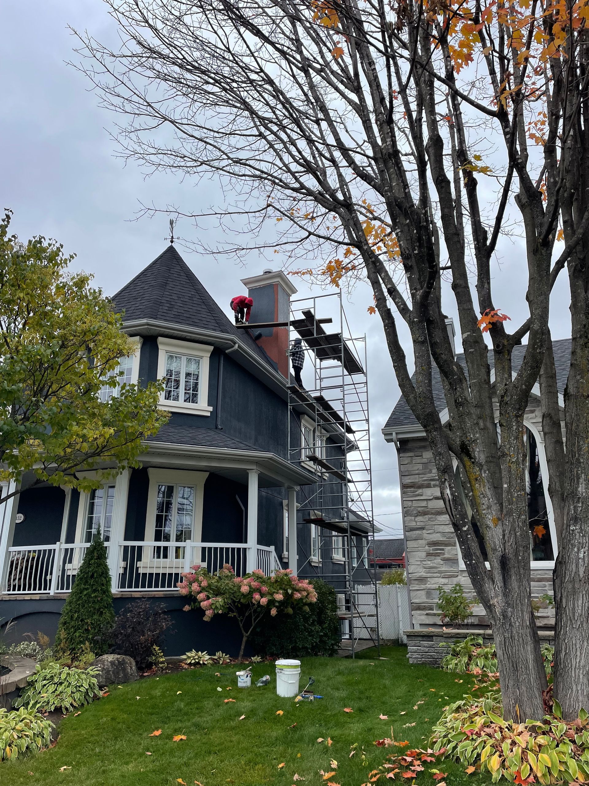 Un homme est debout sur un échafaudage sur le toit d'une maison.