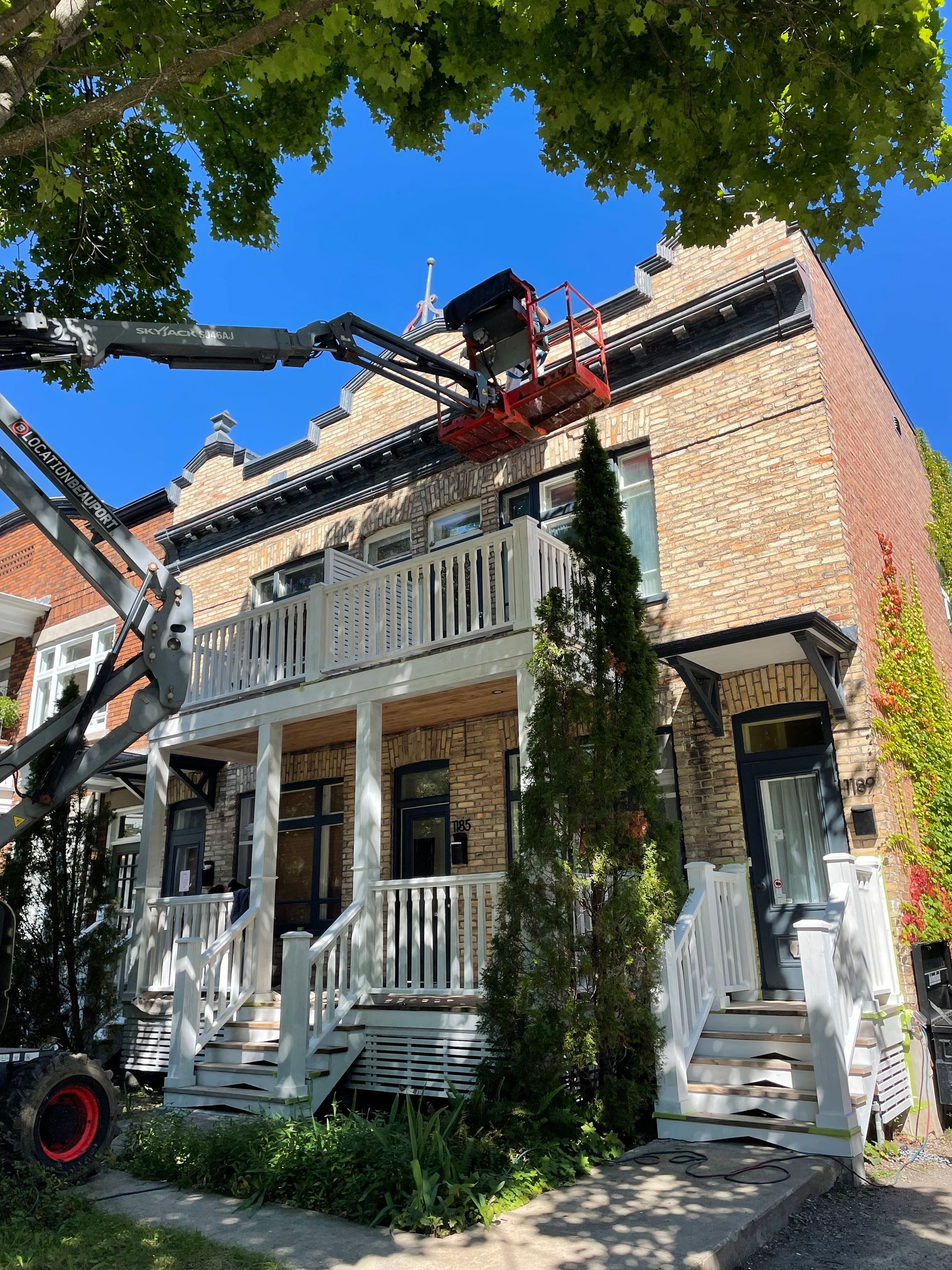 Une grande maison en brique est peinte par une grue.