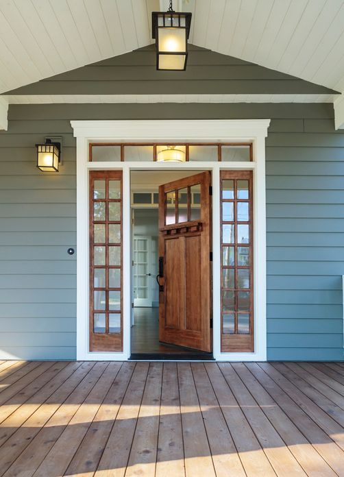 Front porch of blue-gray house with open front doo