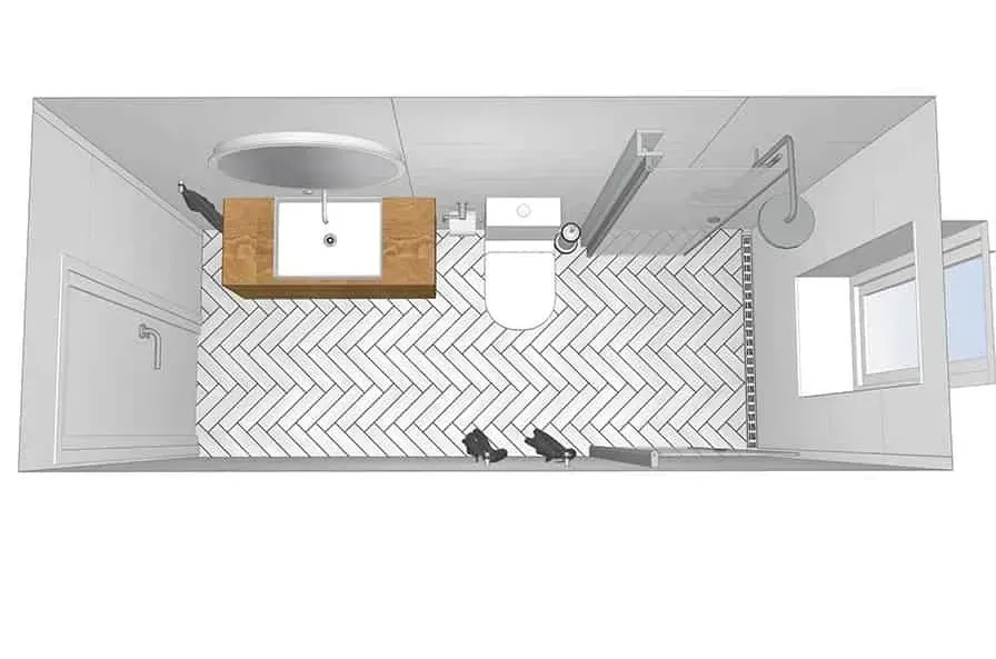 Set ovenfra og ned af et moderne badeværelse med håndvask, toilet, sildebensfliser og brusehoved.