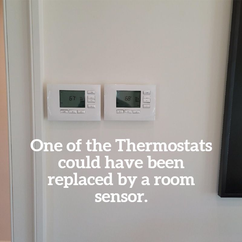 Two white thermostats on a wall, with text suggesting one could be a room sensor.