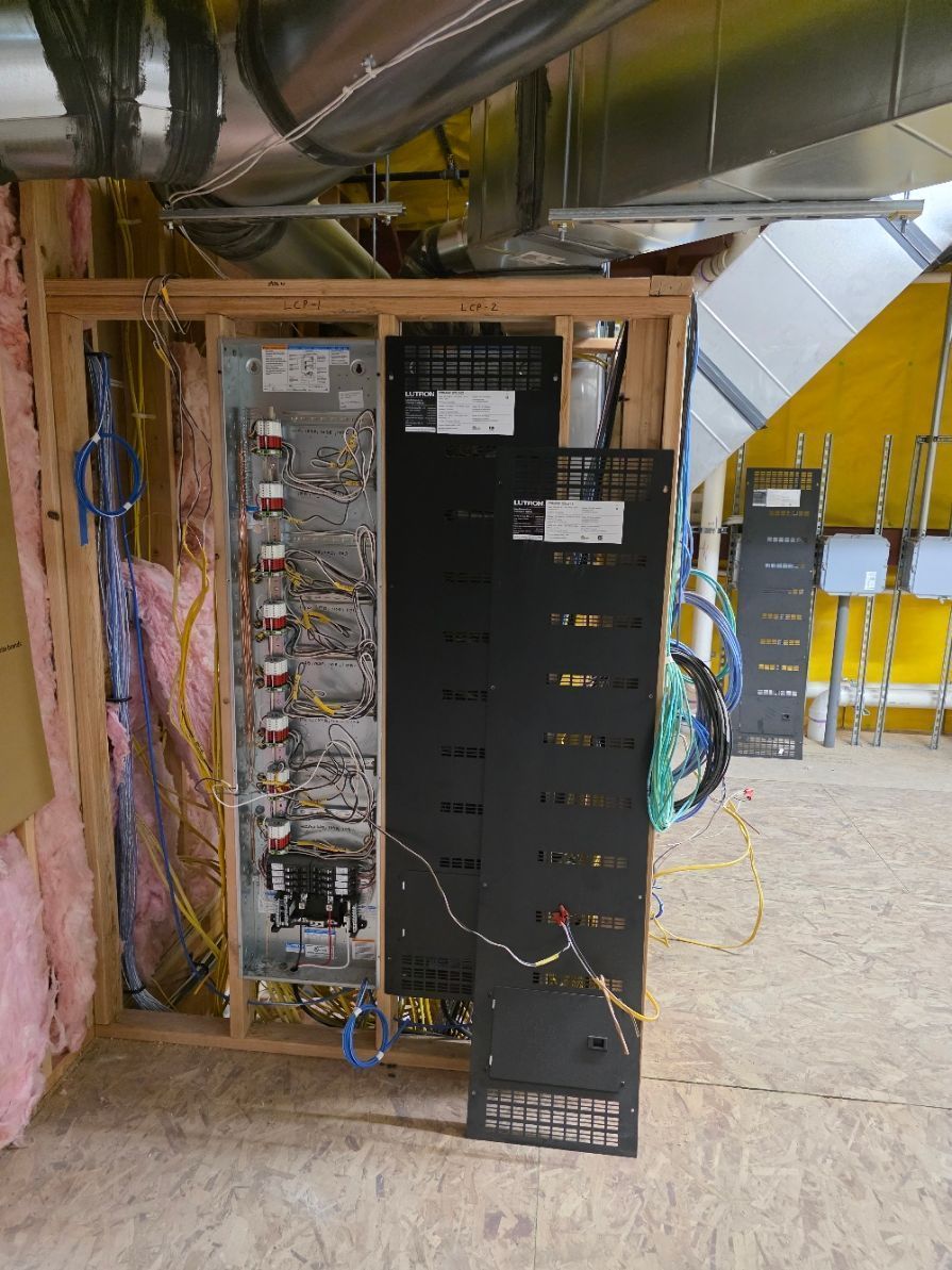 Electrical panels mounted on wooden frame, wiring visible.