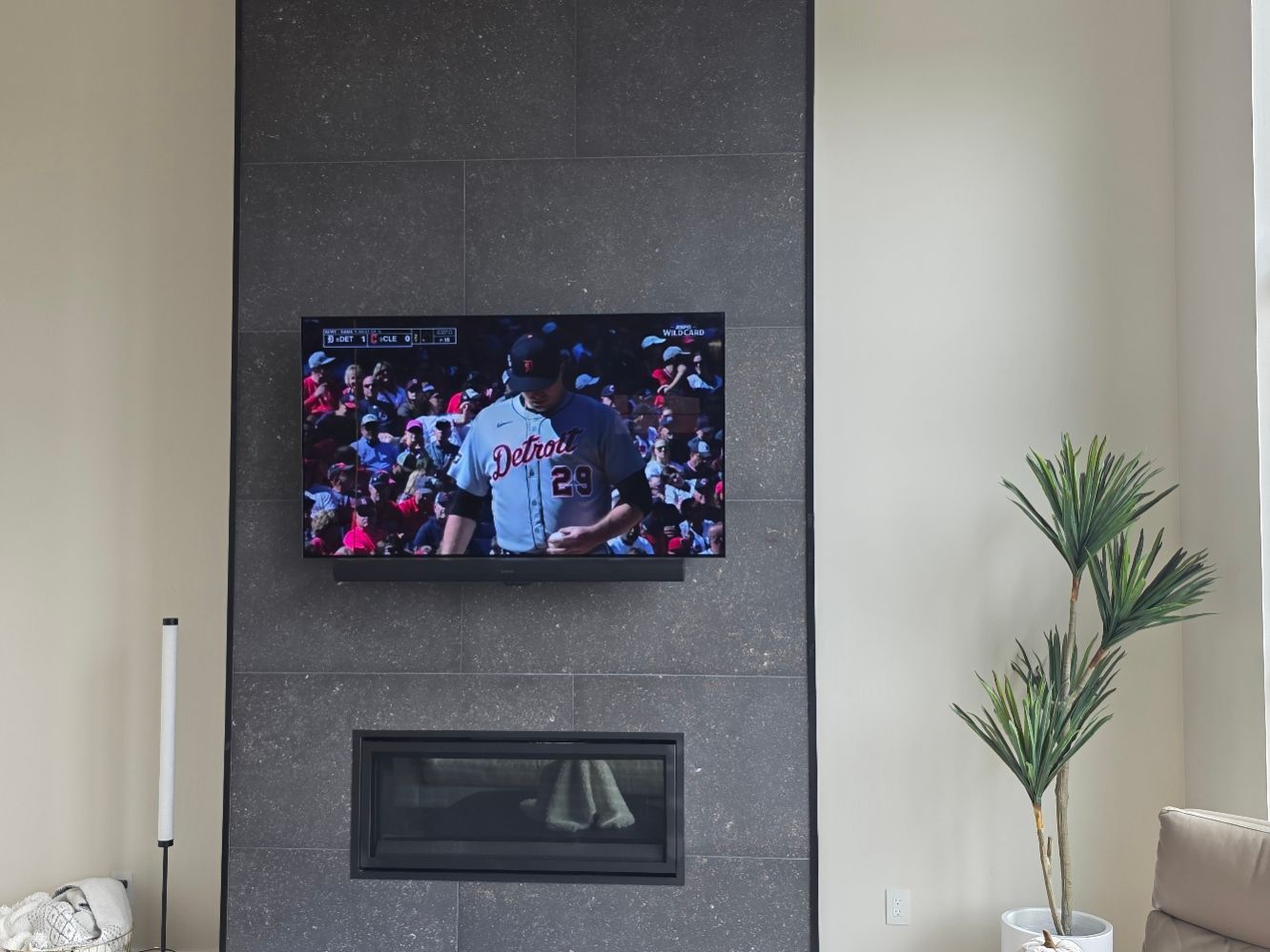 Flat-screen TV mounted above a modern fireplace in a new home near Big Flat Road in Missoula, Montana