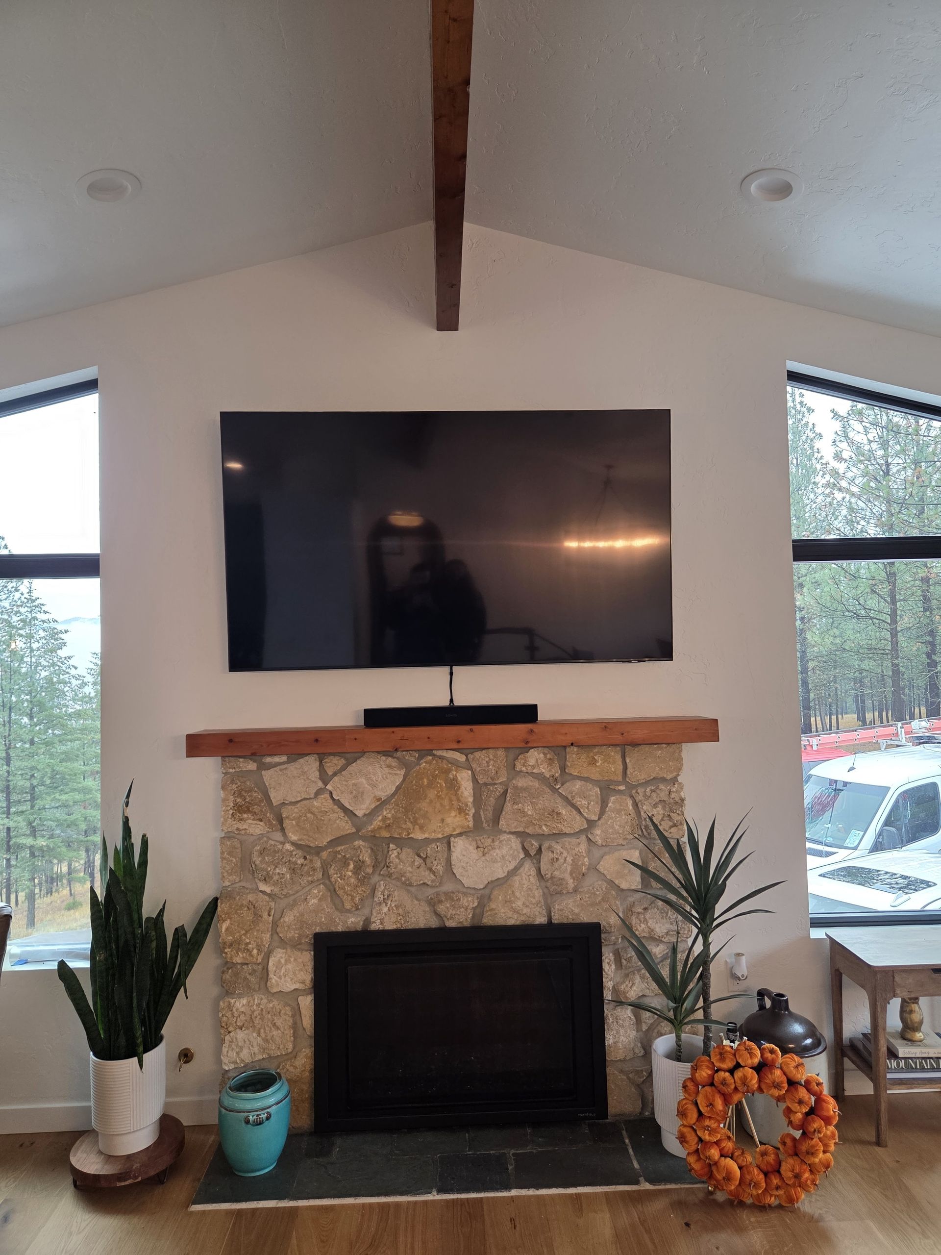 Alt text for this one:
TV mounted above a stone fireplace with Sonos soundbar and in-ceiling speakers.