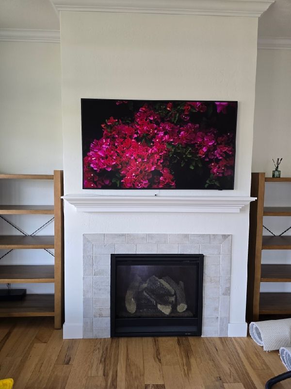 Samsung Frame TV mounted over a fireplace displaying art mode in a Missoula, Montana home, installed by Smart Home Solutions