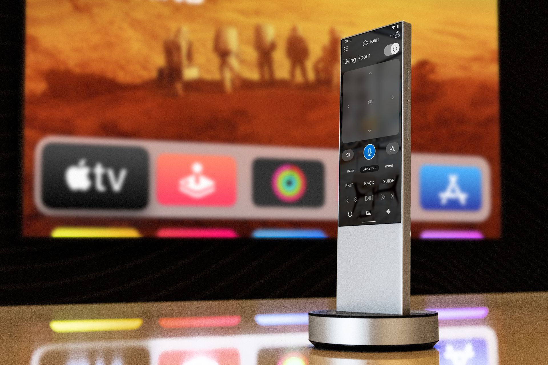 Josh A.I. remote control docked in front of a television showing the Apple TV interface