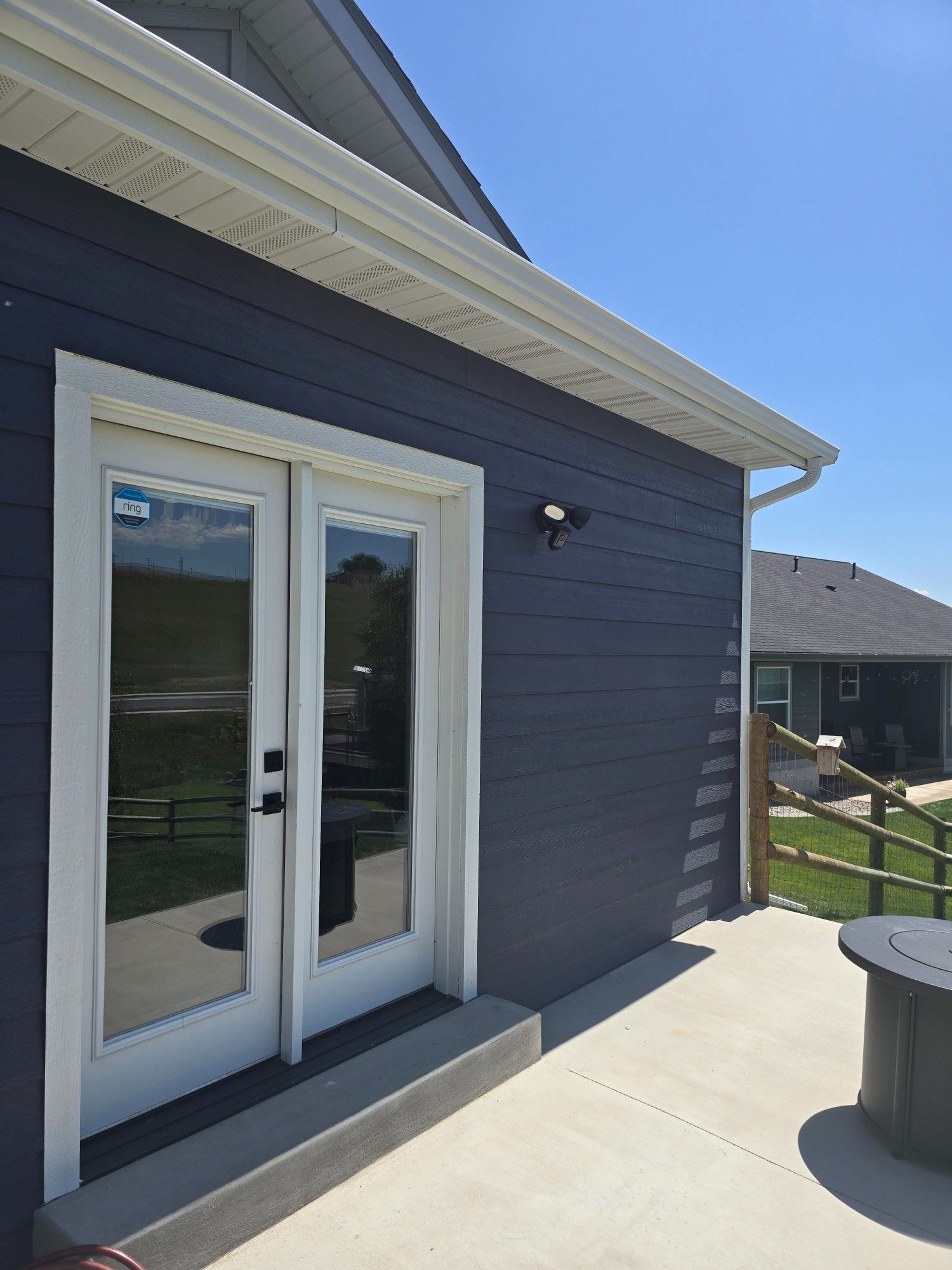 Ring floodlight camera and security system installation on residential back patio in Wye, MT — Smart Home Solutions
Best for Google Business Profile:
Ring Floodlight Cam professionally installed on home exterior in Wye, Montana — certified Ring installer Smart Home Solutions serving Western Montana
This is your strongest of the three photos for SEO because it names a specific brand (Ring) that people actually search for. I'd prioritize placing this one on your future Ring Certified Installer page and on the Wye, MT city page. The visible Ring sticker on the door is also a nice authentic detail that builds trust with potential customers browsing your portfolio.
All three of these photos together tell a complete story of a full-perimeter security install — front, side, and back of the same property. That's excellent portfolio content.Sonnet 4.6